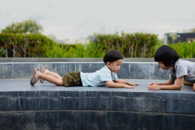 Oğlan dışarıda kızla bir şeyler oynuyor..