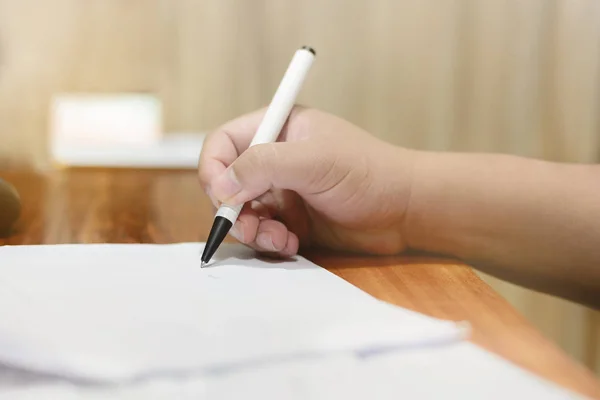 El beyaz kalemi tutuyor. İmzalayacak ya da bir şeyler yazacak..