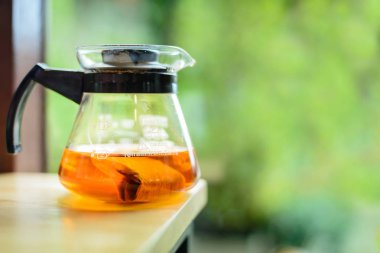 Fotokopi alanı için yeşil arka planda açık ahşap masada çay demliği.