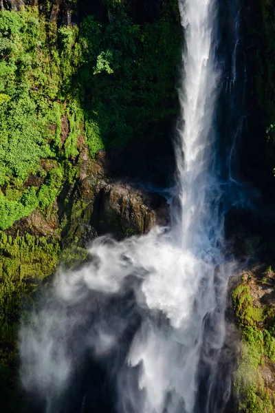 Şelalenin çok büyük miktarda suyu ve çok yüksek damlaları olan bir yakın plan. Bu da çok güzel, beyaz, dağılan bir sisle sonuçlanıyor ve şelalenin etrafında nem yaratıyor..