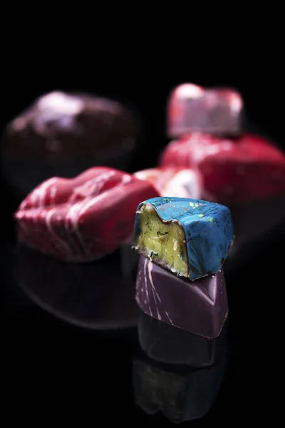 colorful candies in shape of lips with filling on black background