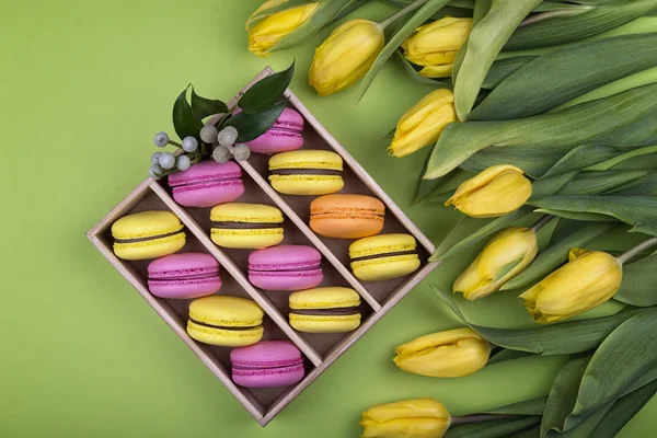 Pembe ve sarı macarons kutusunda taze Lale ile
