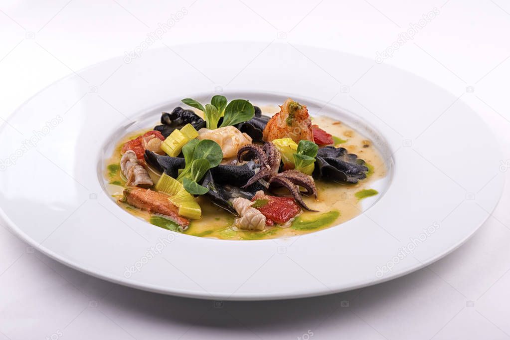 seafood dish garnished with greens in plate on white background