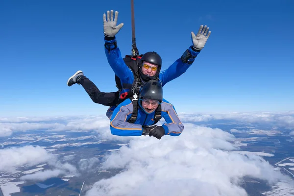 Tandem skydiving. İki adam mavi gökyüzünde eğleniyor musun.