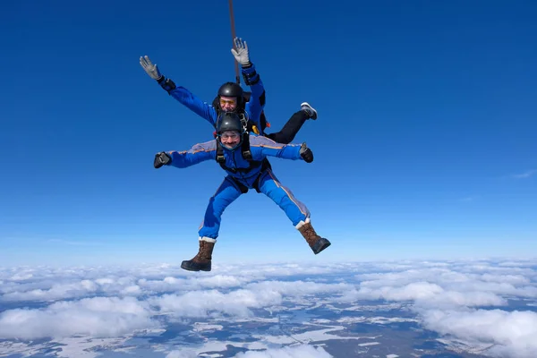 Tandem skydiving. İki adam mavi gökyüzünde eğleniyor musun.