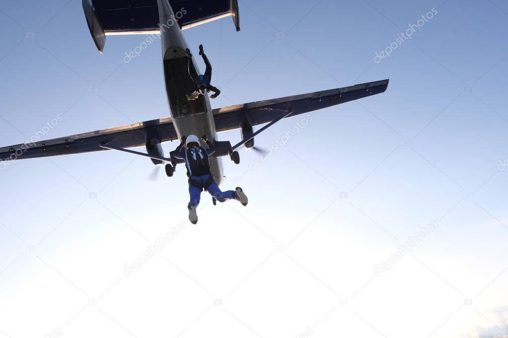 Skydiving. Skydivers are jumping out of a plane.