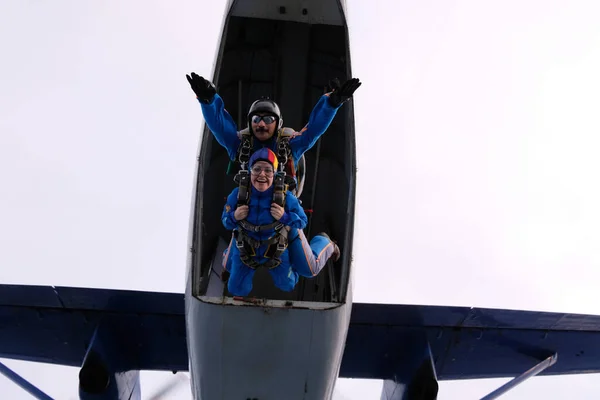 Skydiving. Tandem jump. A woman and her instructor are flying in the sky.