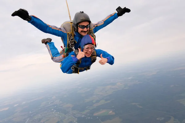 Skydiving. Tandem jump. A woman and her instructor are flying in the sky.
