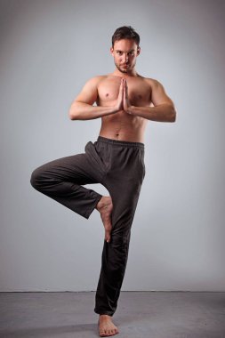 Sakin huzurlu genç ve yalınayak beyaz stüdyoda üstsüz poz, germe beyaz yoga eğitmeni sakallı. Attractie adam pratik yoga gelişmiş. Bir dizi teşkil etmektedir. Akciğer egzersiz yapan adam.