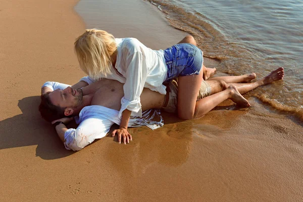 Красивая Счастливая Влюбленная Пара Лежащая Пляже Песке Белых Мокрых Рубашках — стоковое фото