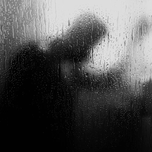 赤裸的男人在淋浴手对着玻璃墙 一个忧郁的迹象 寂寞和悲伤 他的手落在玻璃隔断上 一滴水 — 图库照片