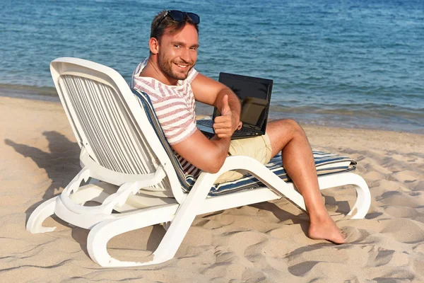 Przystojny Mężczyzna Pracuje Podróżuje Pięknej Plaży Układanie Szezlong Laptopem Kolanach Obrazy Stockowe bez tantiem
