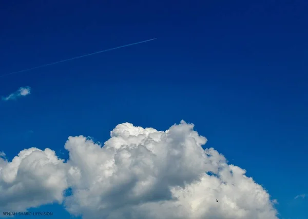 Plane in the Sky. White Line in the Sky. Clouds and Skyscapes. Airplane in the sky with clouds