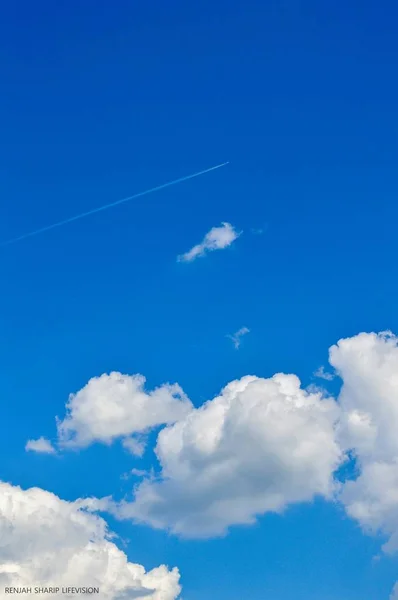 Plane in the Sky. White Line in the Sky. Clouds and Skyscapes. Airplane in the sky with clouds