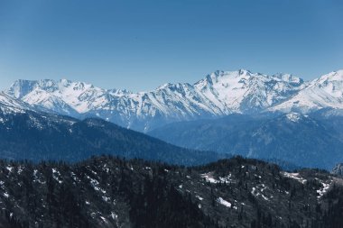 Güneşli havalarda rocky dağlarının karla kaplı tepeler manzara. Doğa ve seyahat kavramı. 