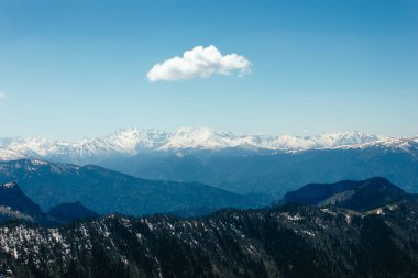 Kar, mavi gökyüzü, Caucasus üzerinde beyaz bulutlar dağların zirveleri ile kaplı