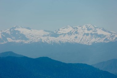 Kar, mavi gökyüzü, Caucasus üzerinde beyaz bulutlar dağların zirveleri ile kaplı