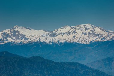 Muhteşem manzarasına Kafkasya dağlarında. Karla kaplı tepeler, mavi gökyüzü, güneşli bir gün