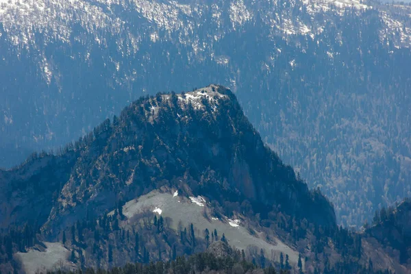 雲の中の青い空の下森林斜面の背景に 春の雪と氷を融解と山脈 — ストック写真