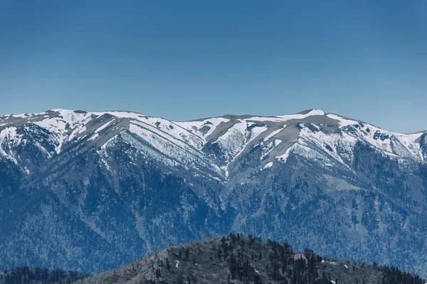 Güneşli havalarda rocky dağlarının karla kaplı tepeler manzara. Doğa ve seyahat kavramı. 