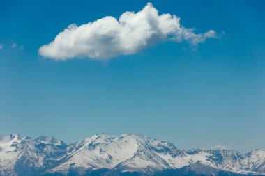 Kar, mavi gökyüzü, Caucasus üzerinde beyaz bulutlar dağların zirveleri ile kaplı