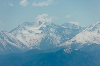 Kar, mavi gökyüzü, Caucasus üzerinde beyaz bulutlar dağların zirveleri ile kaplı