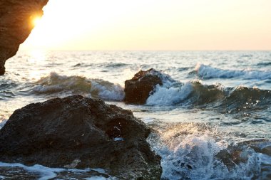  Günbatımı deniz kenarında. Altın kumlar. Dalgalar deniz kumları ve kayalar üzerinde rulo.                              