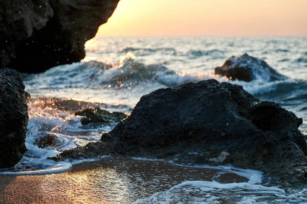 Sunset  at the seaside. Gold sands. Sea waves roll on sands and rocks.