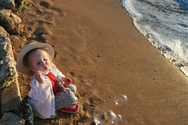   Deniz ve gökyüzü arka plan karşı plaj rahatlatıcı çocuk. Yaz tatil ve seyahat kavramı                             