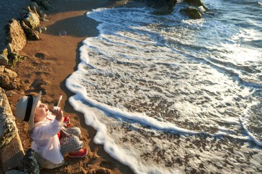 Deniz ve gökyüzü arka plan karşı plaj rahatlatıcı çocuk. Yaz tatil ve seyahat kavramı                               