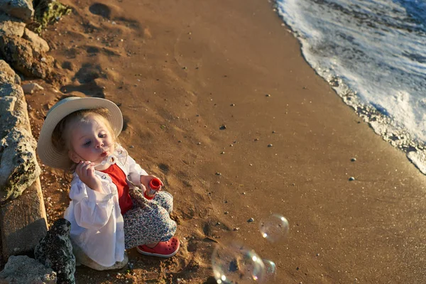   Deniz ve gökyüzü arka plan karşı plaj rahatlatıcı çocuk. Yaz tatil ve seyahat kavramı                             