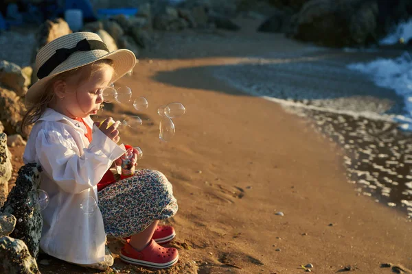 kız sahilde yaz tatillerini üzerinde oynama. Çocuklarda doğa güzel deniz, kum ve mavi gökyüzü. Mutlu çocuklar suda çalışan sahil vacations                               