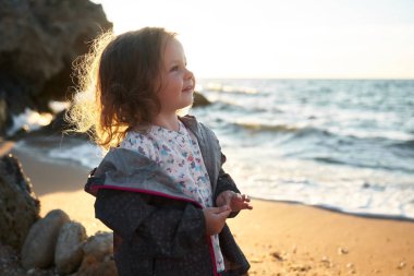 Deniz ve gökyüzü arka plan karşı plaj rahatlatıcı çocuk. Yaz tatil ve seyahat kavramı