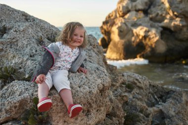 Deniz ve gökyüzü arka plan karşı plaj rahatlatıcı çocuk. Yaz tatil ve seyahat kavramı