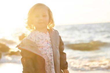 Deniz ve gökyüzü arka plan karşı plaj rahatlatıcı çocuk. Yaz tatil ve seyahat kavramı