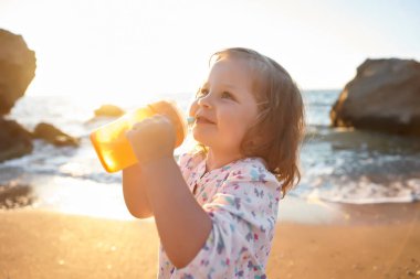 Deniz ve gökyüzü arka plan karşı plaj rahatlatıcı çocuk. Yaz tatil ve seyahat kavramı