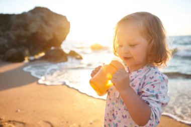 Denizde oynayan mutlu çocuk. Çocuk dışarıda eğleniyor. Yaz tatili ve sağlıklı yaşam tarzı konsepti.