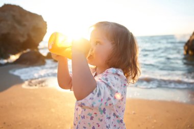 kız sahilde yaz tatillerini üzerinde oynama. Çocuklarda doğa güzel deniz, kum ve mavi gökyüzü. Mutlu çocuklar suda çalışan sahil vacations