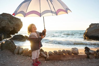 Deniz ve gökyüzü arka plan karşı plaj rahatlatıcı çocuk. Yaz tatil ve seyahat kavramı