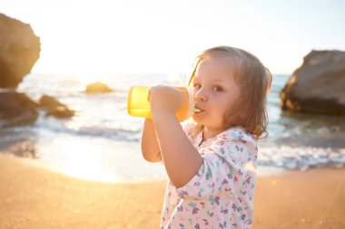 Deniz ve gökyüzü arka plan karşı plaj rahatlatıcı çocuk. Yaz tatil ve seyahat kavramı
