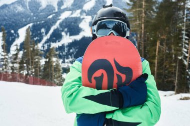 Snowboard üstüne yakın tepeye portre, kar dağların yamaçlarında snowboard snowboard tutun