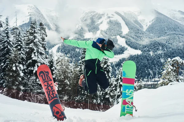 Arka planda derin mavi gökyüzü ile havada zıplayan snowboardcu