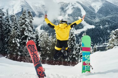 Arka planda derin mavi gökyüzü ile havada zıplayan snowboardcu