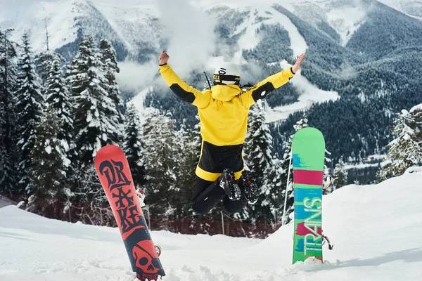 Arka planda derin mavi gökyüzü ile havada zıplayan snowboardcu