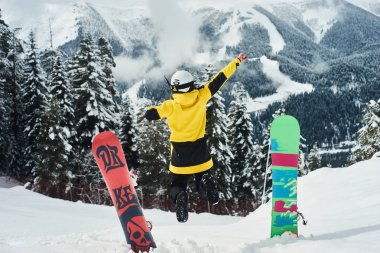 Arka planda derin mavi gökyüzü ile havada zıplayan snowboardcu
