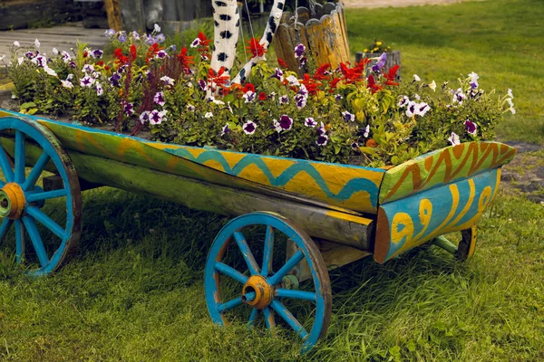 A cart full of flowers close-up on a green lawn