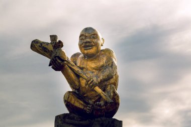 Köylü yakın çekim onun elinde bir kulüp ile bir günlük heykeli kesim