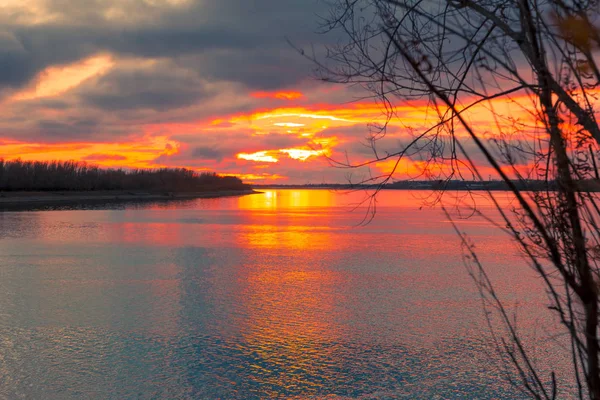 明るいオレンジ色の太陽が川の上の地平線をを超えてください — ストック写真