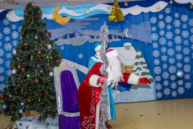 Noel Noel Baba'ya kırmızı bir kaftan çocuk tanışmaya hazır yılbaşı ağacının yanındaki elinde bir personel ile