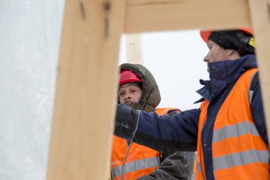 İşçiler Noel tatili için buz bloklarından bir buz kasabası inşa ediyorlar.